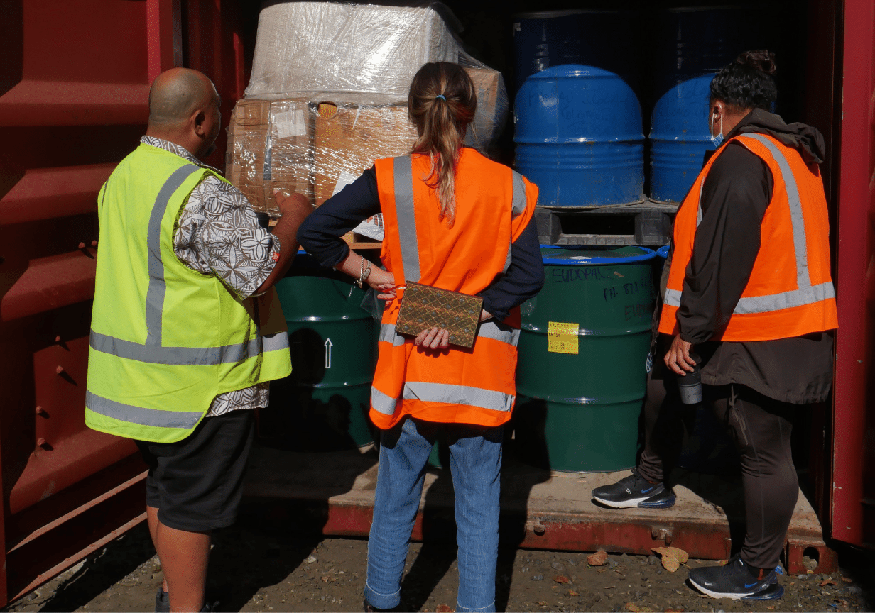 An image of people examining the contents of a shipping container full of supplies, symbolising AWA and it's work during emergencies